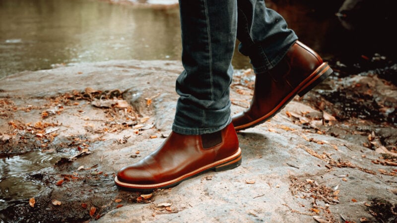 Man walking near water in his Nisolo Javier boots