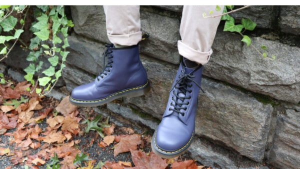 Model sitting on the wall and wearing Dr Martens 1460