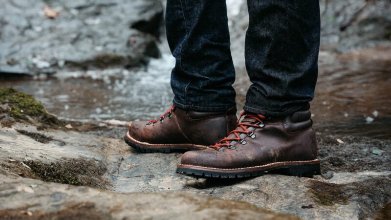 Model standing near creek in Velasca Resegott boots